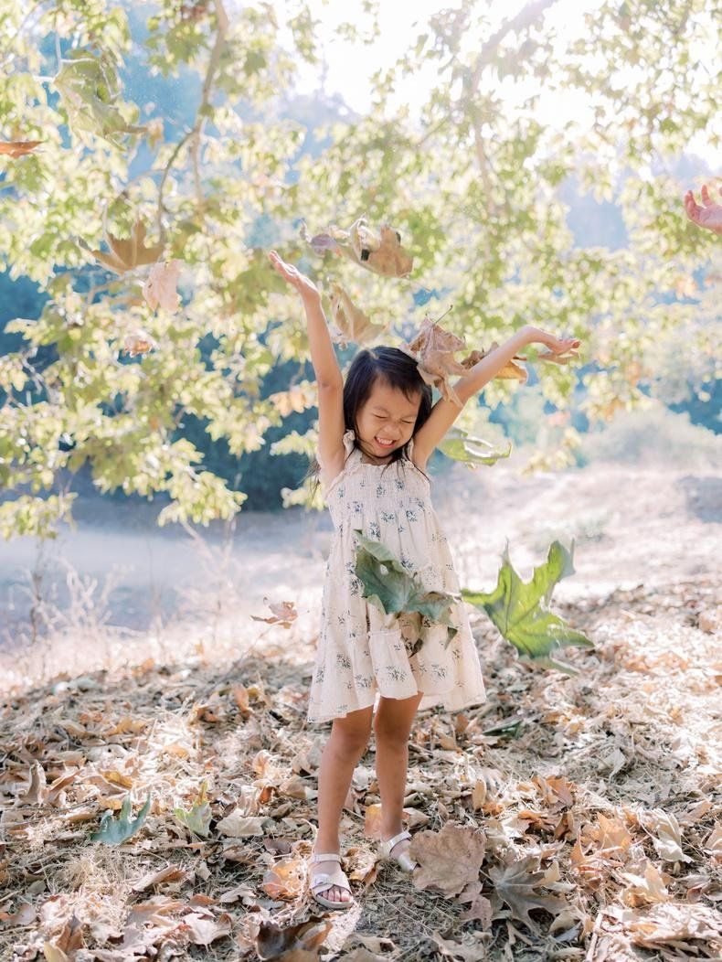 Child laughing during a fall family photo session in Los Angeles