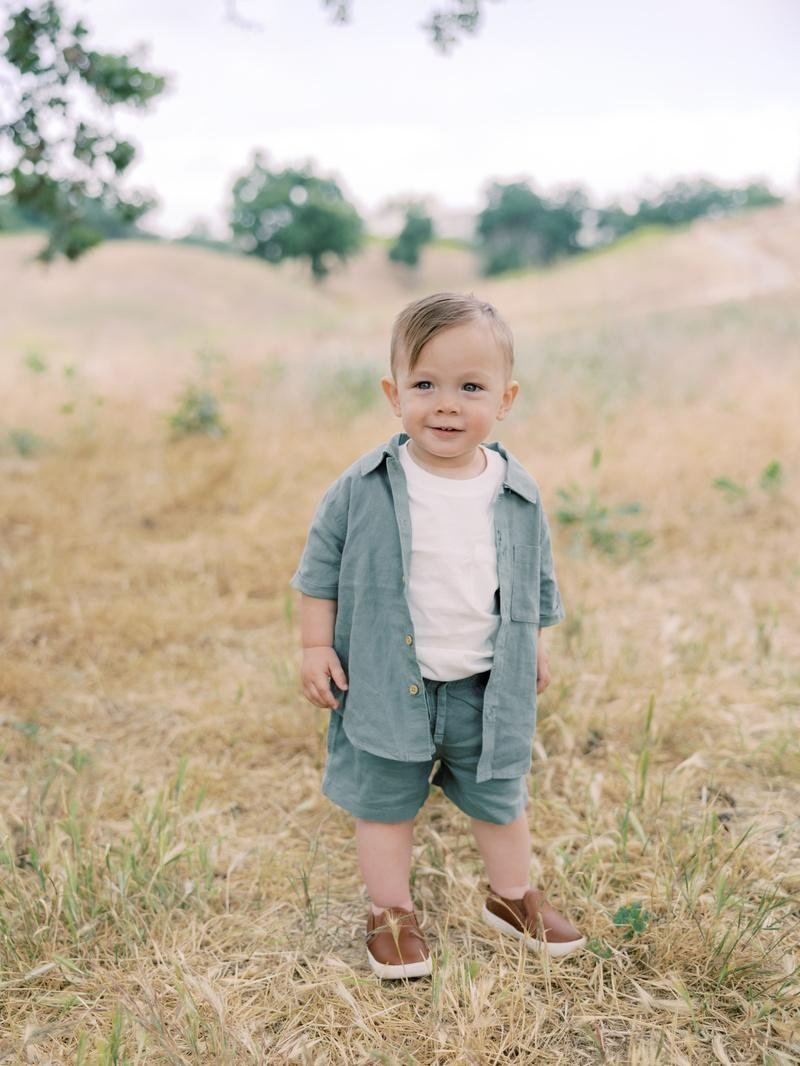 Toddler standing in golden grass at a fall mini session