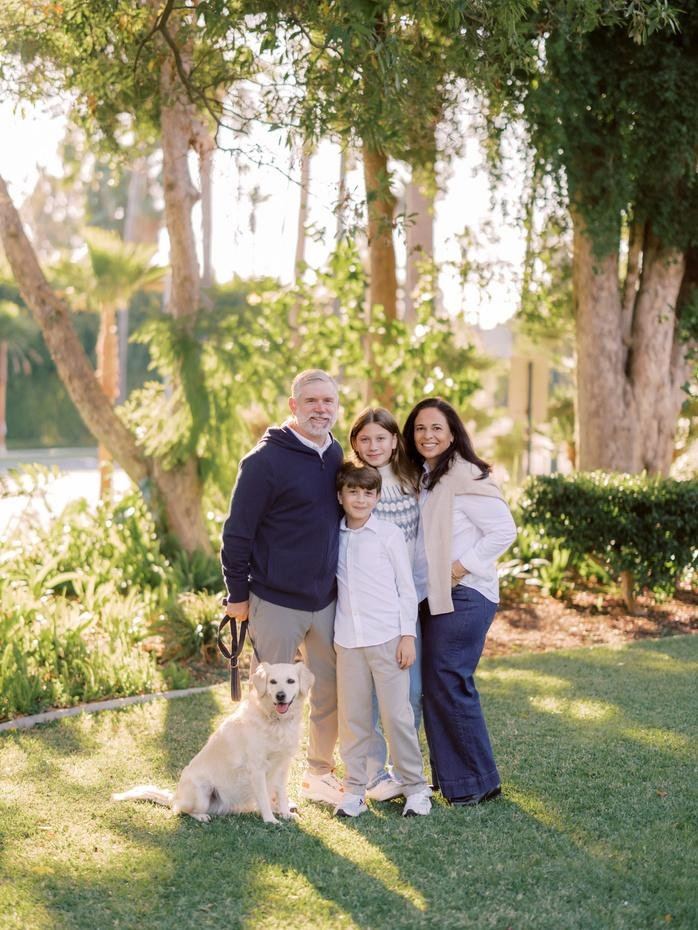 Family with their golden retriever on the grass in a Beverly Hills park